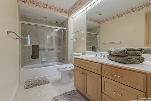 full bathroom featuring toilet, combined bath / shower with glass door, large vanity, and tile floors