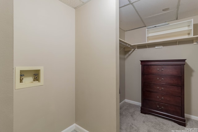 walk in closet featuring light colored carpet