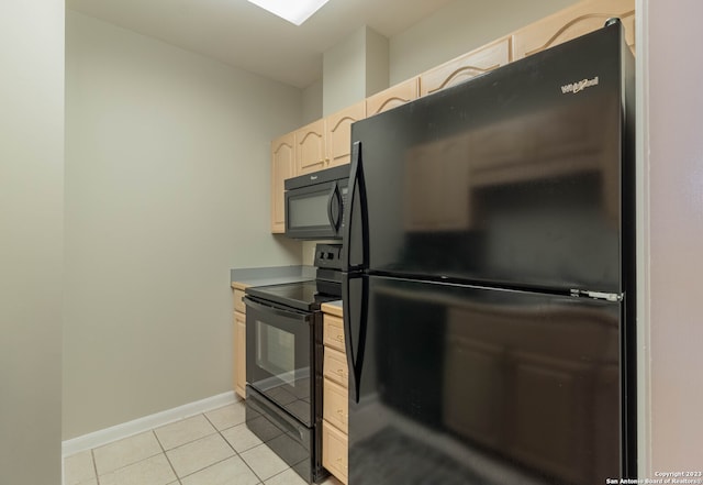 kitchen featuring light brown cabinets, light tile floors, and black appliances