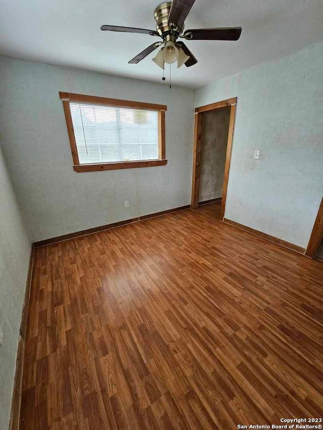 empty room featuring dark hardwood / wood-style flooring and ceiling fan