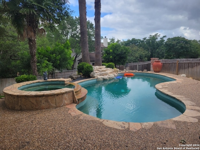 view of swimming pool with an in ground hot tub