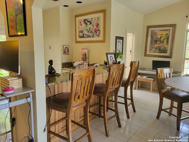 interior space featuring light tile patterned flooring and vaulted ceiling