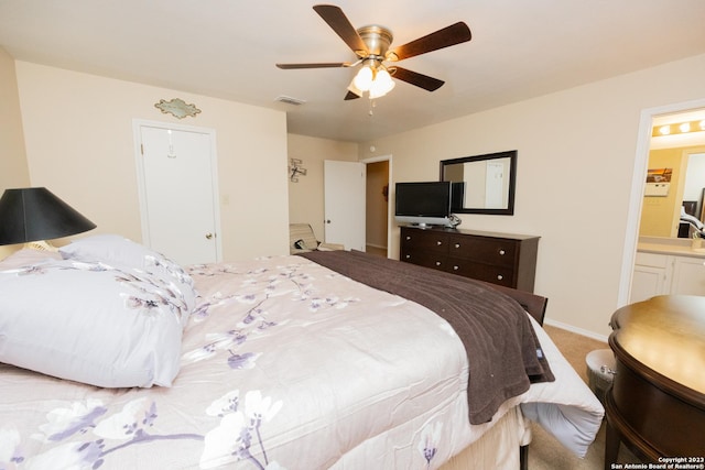 bedroom featuring ensuite bath, light colored carpet, a closet, and ceiling fan