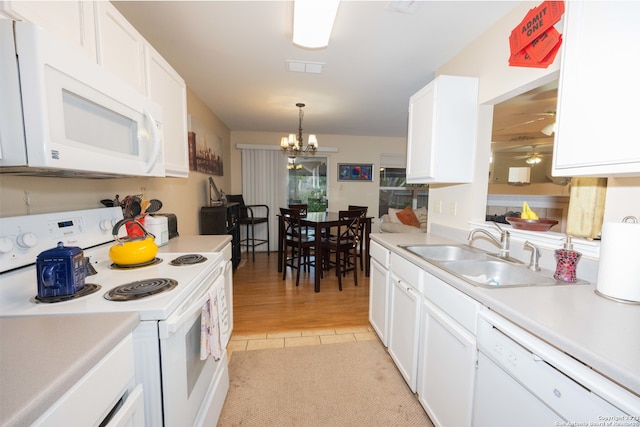 kitchen with pendant lighting, sink, white appliances, light tile patterned floors, and white cabinetry