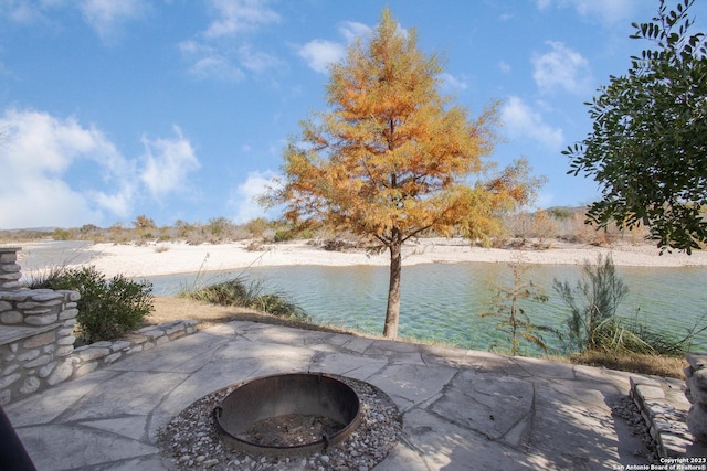 view of patio / terrace featuring a water view and an outdoor fire pit