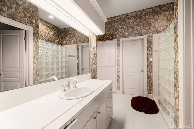 bathroom featuring a shower, crown molding, and vanity