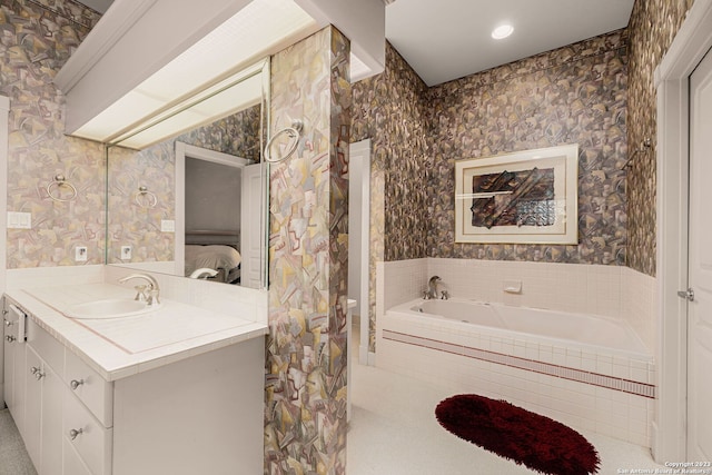 bathroom with vanity and a relaxing tiled tub