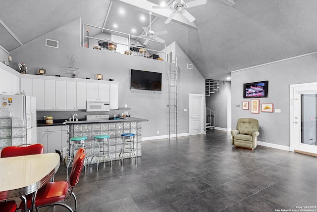 kitchen with a breakfast bar, white cabinets, white appliances, and high vaulted ceiling