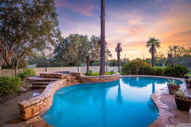 view of pool at dusk