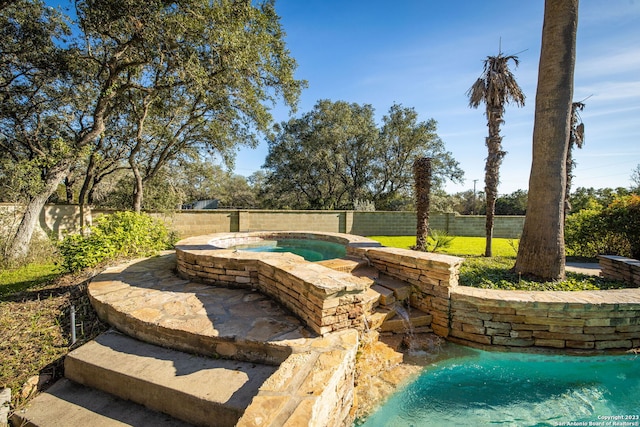 exterior space featuring an in ground hot tub