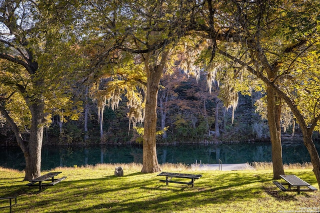 view of property's community with a lawn and a water view