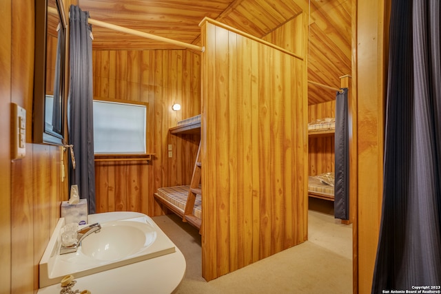 bathroom with wood walls, vanity, wooden ceiling, and vaulted ceiling