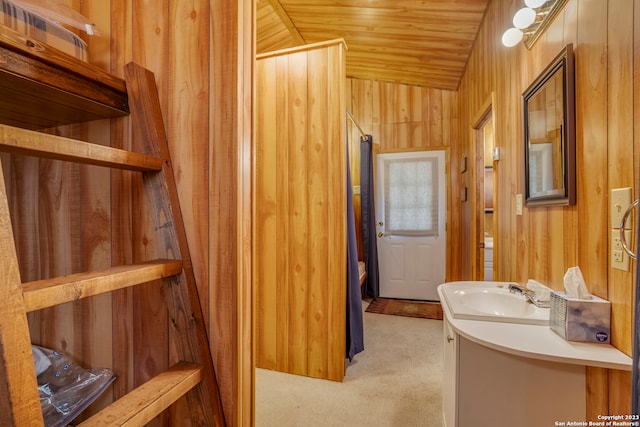 bathroom featuring wood walls, vanity, and wooden ceiling