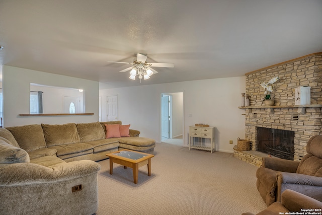 carpeted living room with ceiling fan and a fireplace