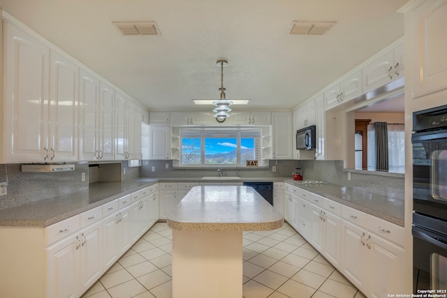 kitchen with a kitchen island, decorative light fixtures, tasteful backsplash, and white cabinetry