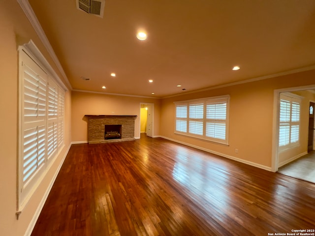 unfurnished living room with a fireplace, crown molding, hardwood / wood-style floors, and a wealth of natural light