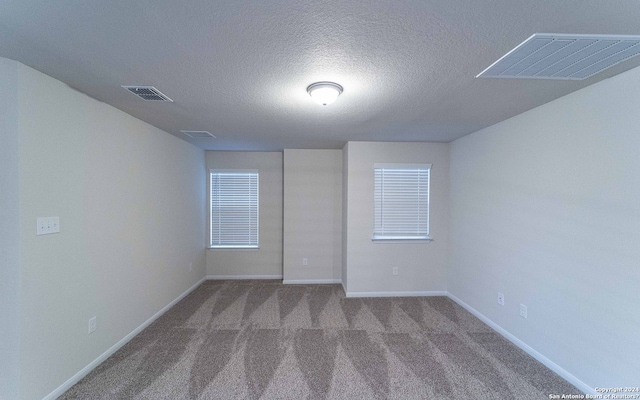 unfurnished room featuring carpet floors and a textured ceiling