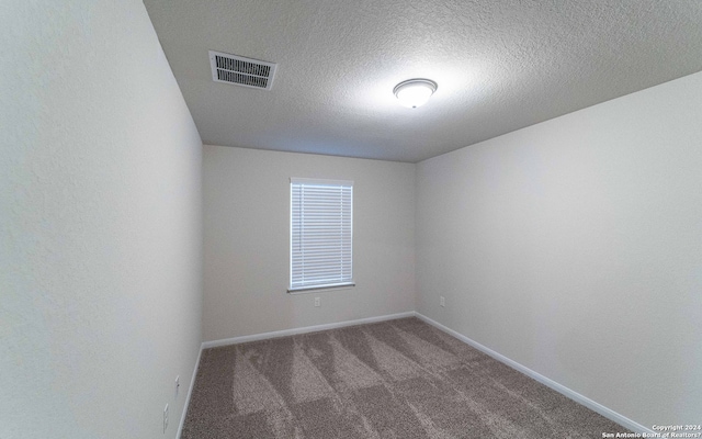 unfurnished room featuring carpet flooring and a textured ceiling