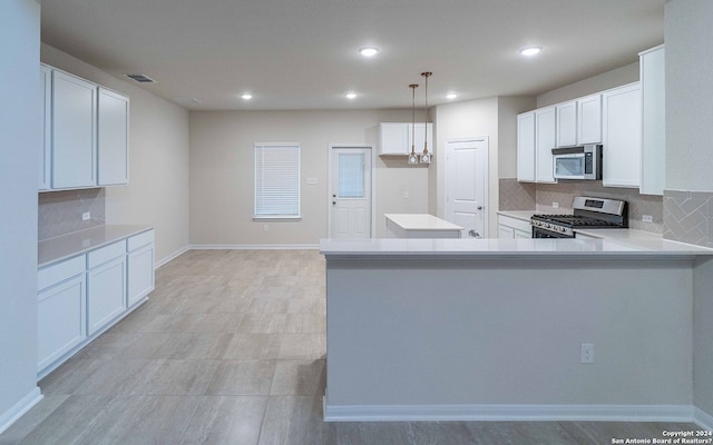 kitchen featuring white cabinetry, stainless steel appliances, pendant lighting, decorative backsplash, and kitchen peninsula