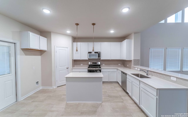 kitchen with light tile patterned floors, a center island, stainless steel appliances, decorative light fixtures, and sink