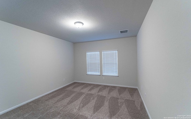 unfurnished room with carpet floors and a textured ceiling