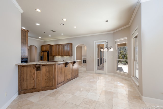 kitchen featuring hanging light fixtures, crown molding, a breakfast bar area, high quality fridge, and light tile floors