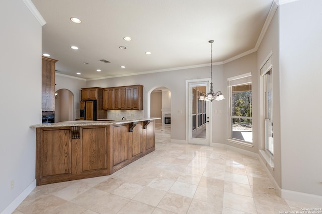 kitchen featuring brown cabinetry, arched walkways, visible vents, and fridge with ice dispenser