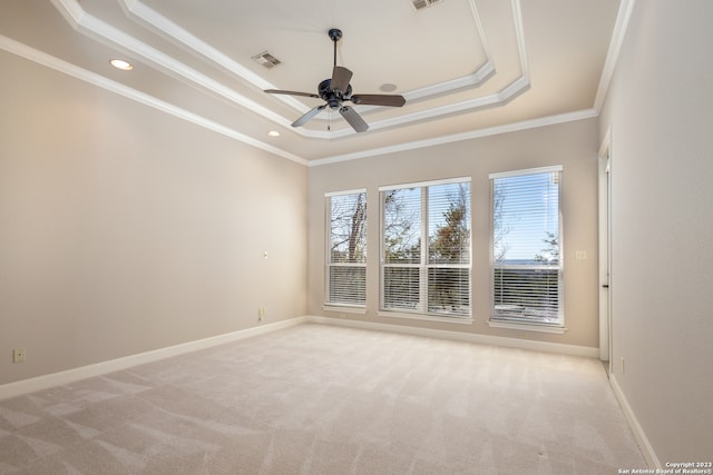 carpeted empty room featuring ceiling fan, a raised ceiling, and crown molding