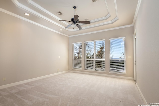 spare room with light carpet, a raised ceiling, visible vents, and baseboards