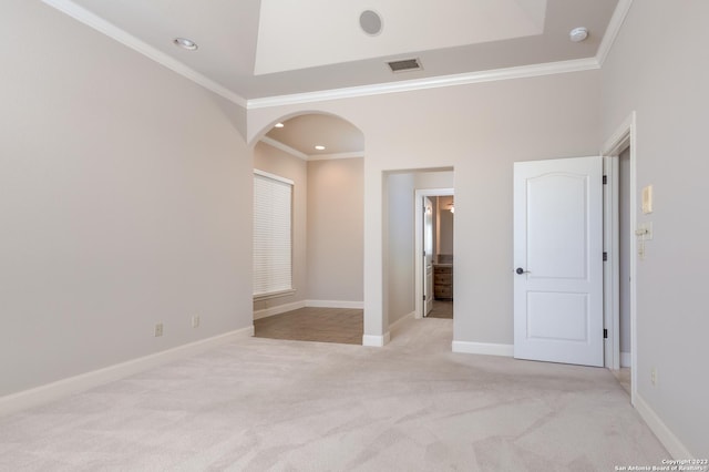 unfurnished bedroom with arched walkways, ornamental molding, light carpet, and visible vents