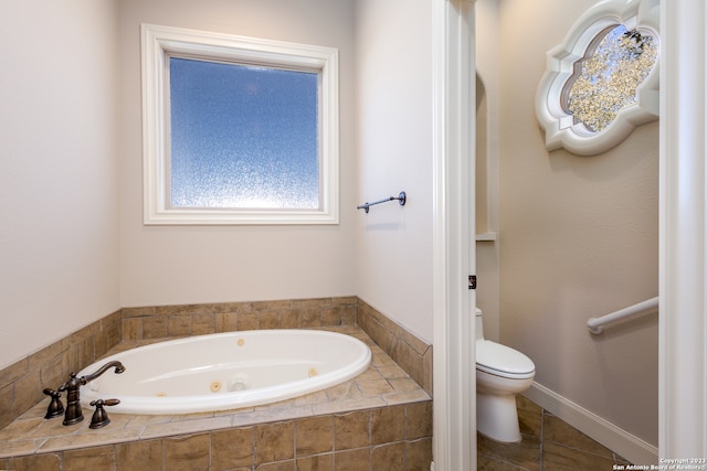 bathroom featuring tile floors, tiled bath, and toilet