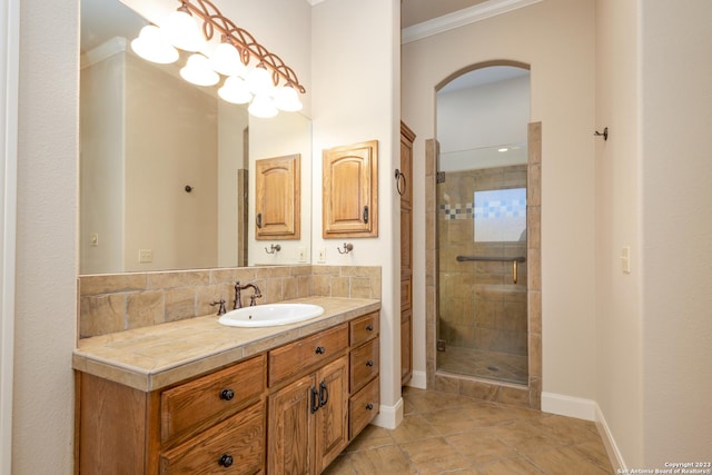 bathroom featuring crown molding, decorative backsplash, a stall shower, vanity, and baseboards