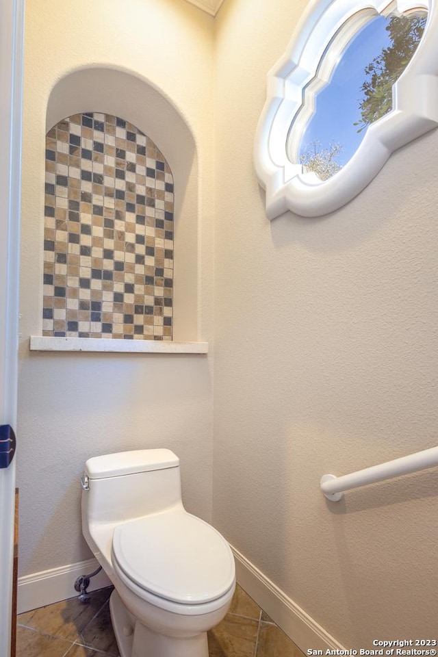 bathroom with tile patterned flooring, toilet, and baseboards