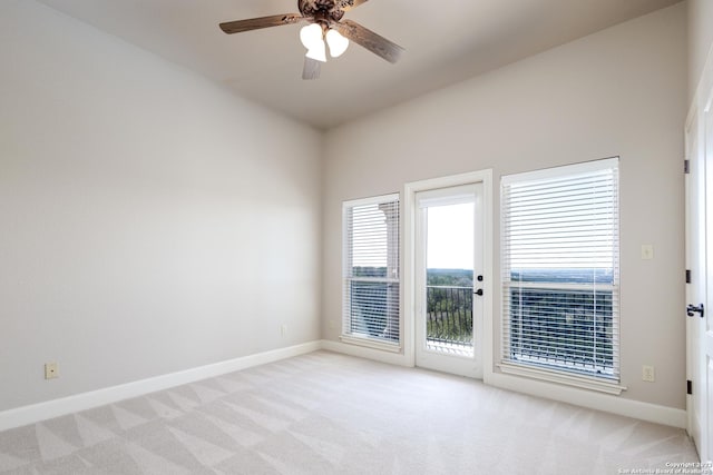 empty room featuring baseboards, ceiling fan, and light colored carpet