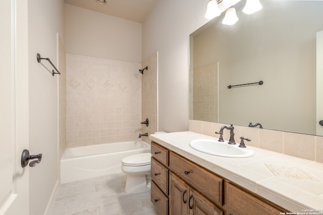 full bathroom featuring tile floors, tiled shower / bath, oversized vanity, and toilet