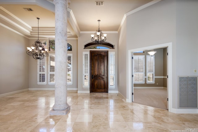 foyer entrance featuring a chandelier, decorative columns, and visible vents