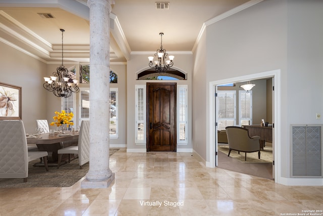 foyer with a chandelier, decorative columns, and tile floors