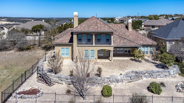 rear view of house with a patio, stucco siding, a tile roof, and fence