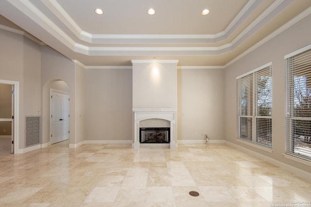 unfurnished living room featuring baseboards, a tray ceiling, a high end fireplace, and crown molding