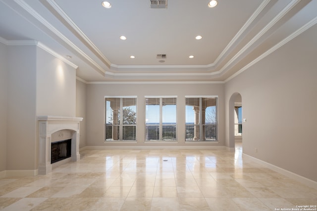 unfurnished living room with a tray ceiling and light tile floors