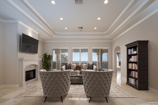 living room featuring a raised ceiling, a fireplace, and light tile floors