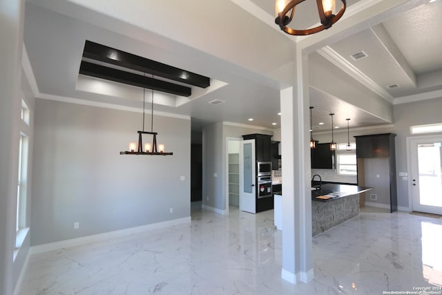 kitchen with sink, crown molding, a chandelier, appliances with stainless steel finishes, and a tray ceiling