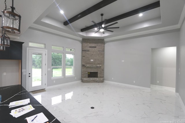 unfurnished living room with ceiling fan, crown molding, a fireplace, and a tray ceiling