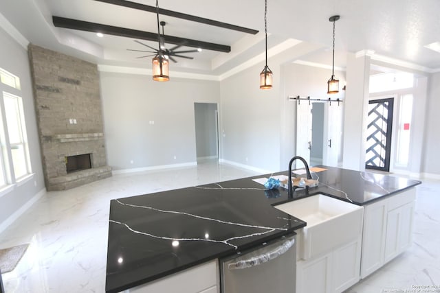 kitchen with white cabinetry, a barn door, sink, and a tray ceiling