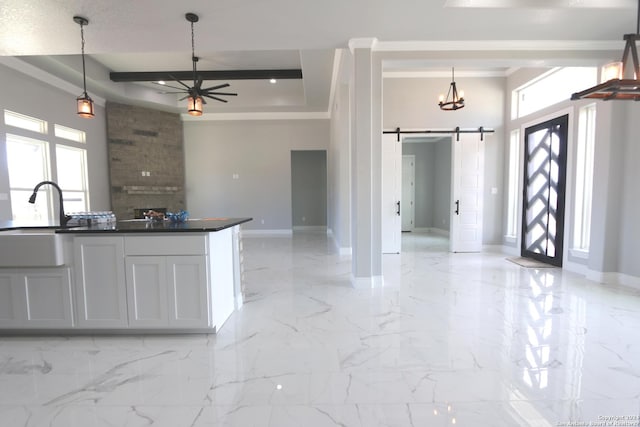 kitchen with a barn door, sink, a wealth of natural light, and white cabinets