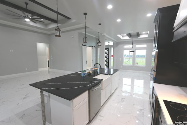 kitchen with white cabinetry, appliances with stainless steel finishes, a raised ceiling, an island with sink, and a barn door