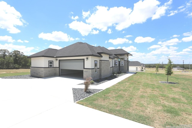 prairie-style home featuring a garage and a front lawn