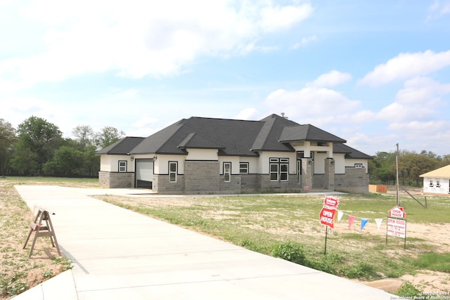 view of front of property featuring a garage and a front lawn