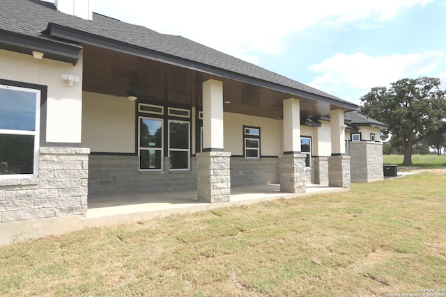 view of home's exterior featuring ceiling fan and a lawn