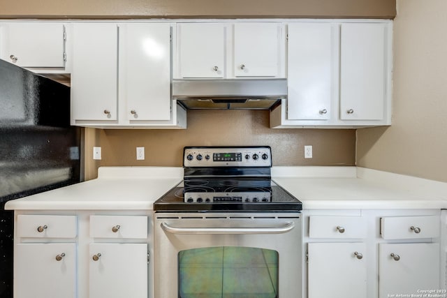 kitchen with black fridge, white cabinetry, stainless steel range with electric cooktop, and range hood